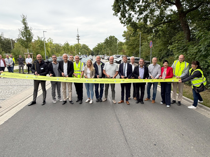 Oberbürgermeister Dennis Weilmann und Erster Stadtrat und Stadtbaurat Kai-Uwe Hirschheide mit Vertreter*innen von Stadt, Klinikum und Politik beim symbolischen Durchschneiden des Bandes.