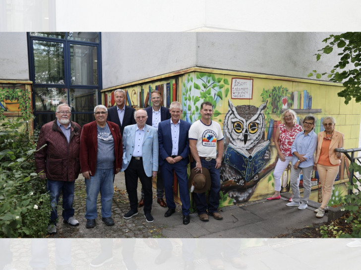 Gruppenbild vor der Außenfassade (v. l. Werner Müller (Ortsbürgermeister), Muzaffer Perik (Ratsherr SPD), Jan Erik Bohling (zuständiger Stadtrat), Hans Verstegen (stellv. Ortsbürgermeister), Michael Tacke (Stadtbaurat), Oberbürgermeister Frank Klingebiel, Ronny Knorr, Barbara Henning (Stadtbibliothek), Sylvia Fiedler (Leiterin der Stadtbibliothek) und Karin Verstegen (1. Vorsitzende der Bibliotheksgesellschaft).