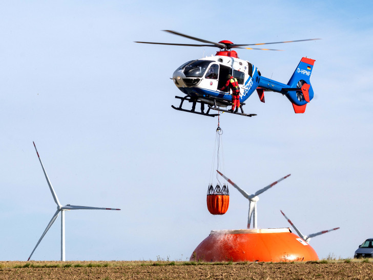 asseraufnahme im Flug: Der Hubschrauber taucht den „Bambi Bucket“ in den mit Löschwasser gefüllten Flex-Tank ein und kann ihn so ohne Befüllungsmannschaft am Boden aufnehmen.