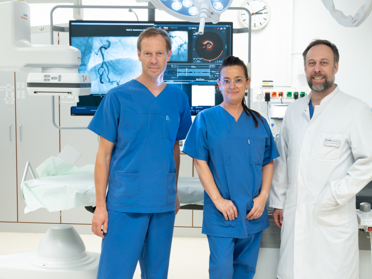 Präsentieren das mordernisierte Herzkatheterlabor (v. l.): Oberarzt Dr. Andreas Klumb, Leiter der Herzkatheterlabore; Ana-Maria Ayala-Vargas, Koordinatorin im Herzkatheterlabor und Prof. Dr. Tibor Kempf, Chefarzt der Klinik für Kardiologie und Intensivmedizin.